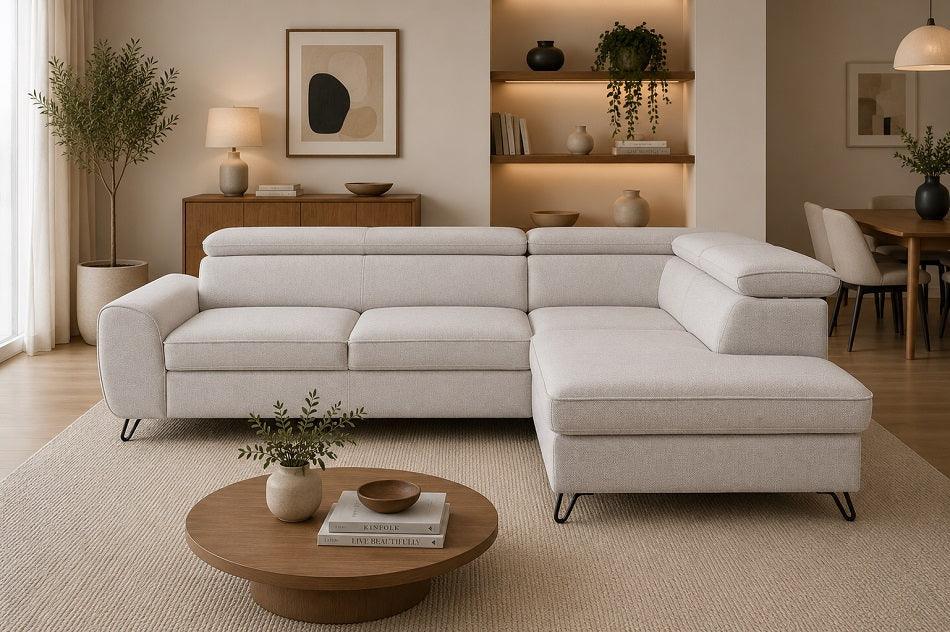 A modern light beige sectional sofa with a chaise lounge, styled in a warm, contemporary living room with a round wooden coffee table, textured rug, and built-in shelving.